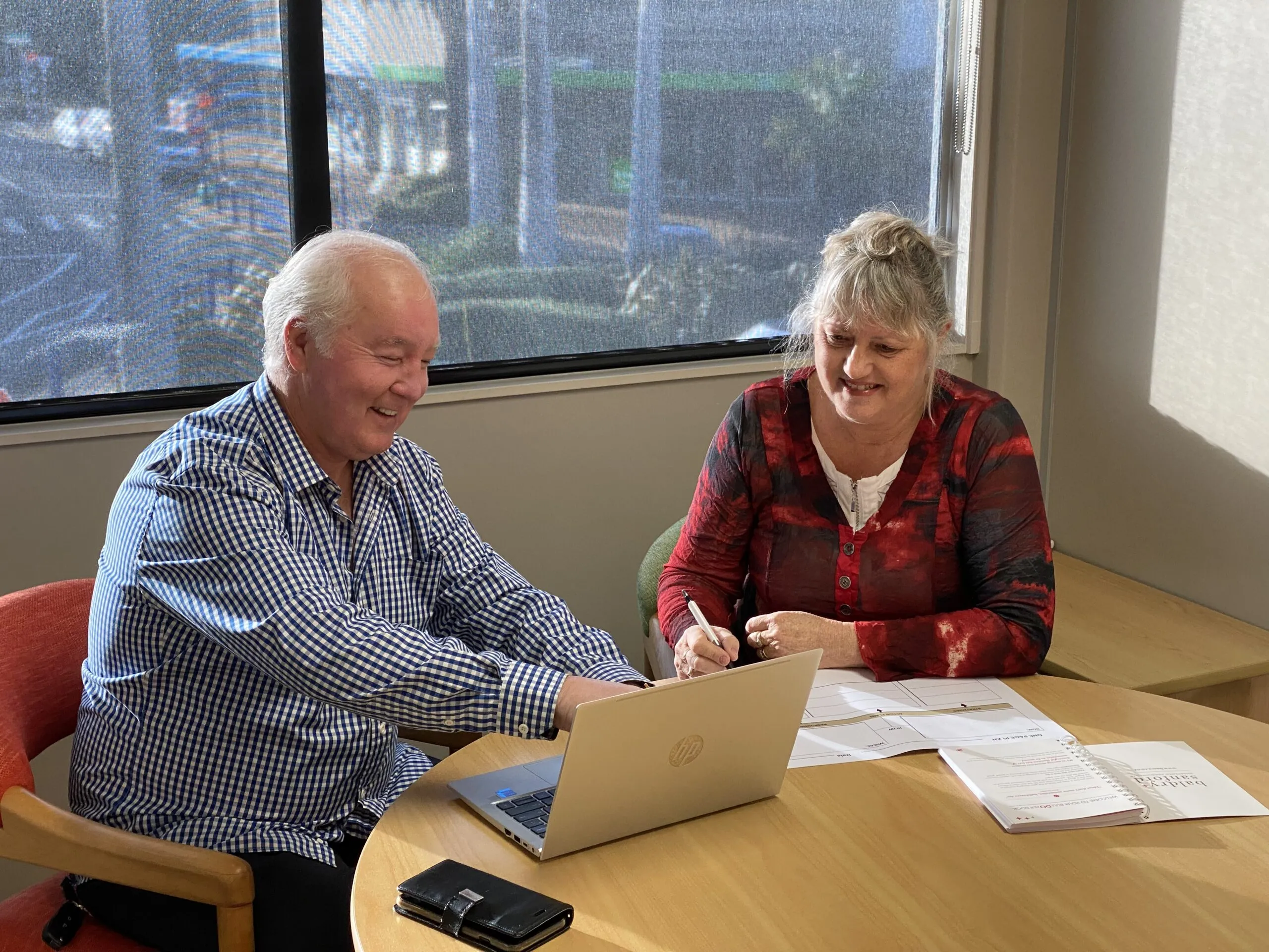 Two First Rate Mortgages advisers going over loan documents at a laptop